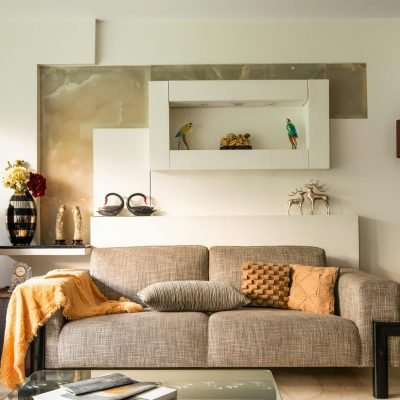 Cozy living room featuring a sofa, decorative items, and a piano, perfect for a stylish home interior.